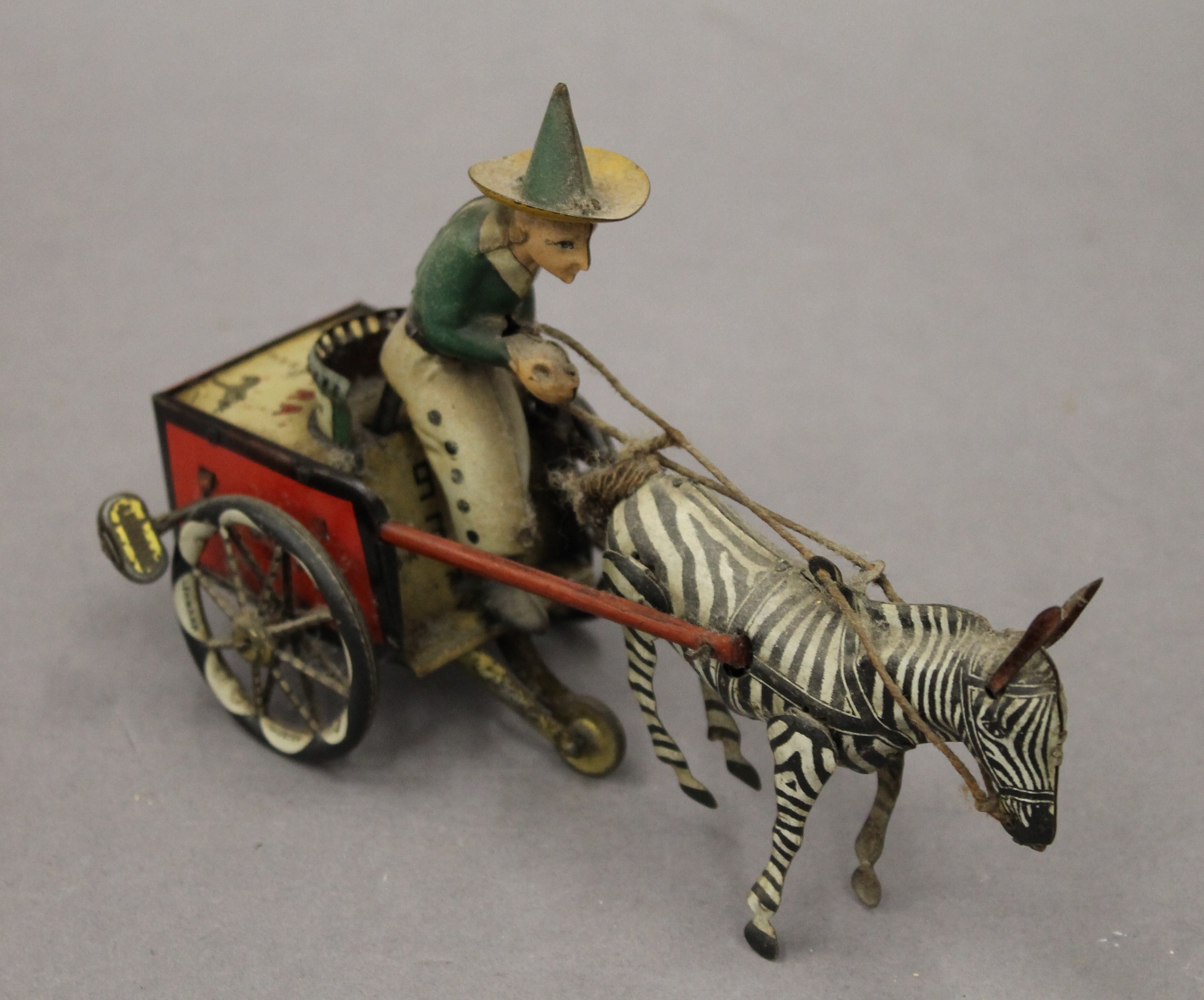 A Lehman tin plate clockwork model of a zebra and cart. 18 cm long.