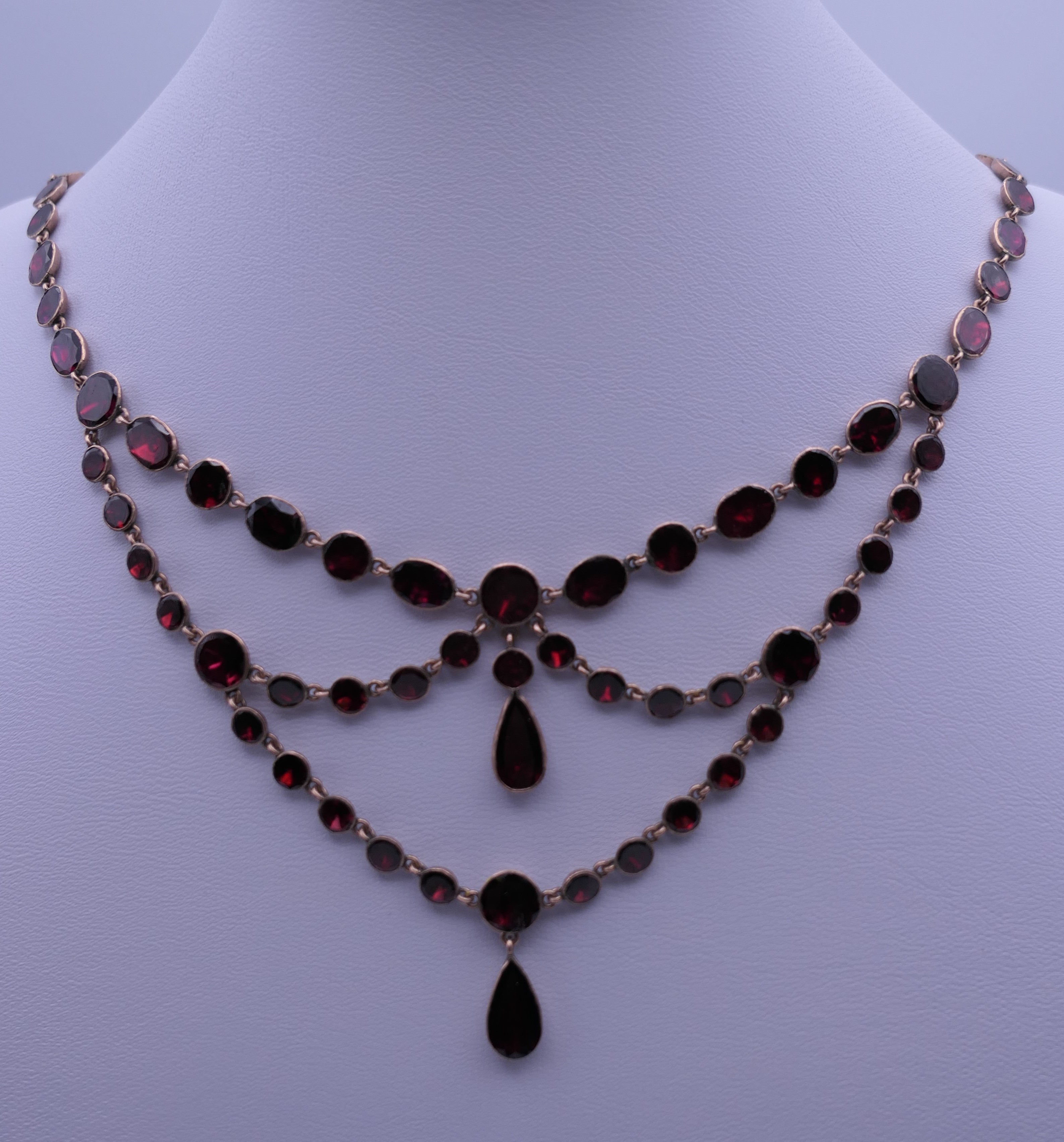 A 9 KT gold almandine garnet set necklace. 45 cm long.