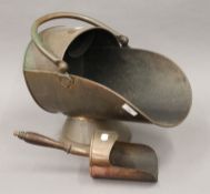 A copper coal scuttle, a coal shovel, a brass oil lamp and a warming pan.