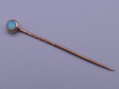 An opal mounted unmarked stickpin, housed in a leather box. 5.5 cm long.