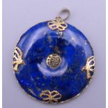 A Chinese 14 ct gold mounted lapis pendant. 3.5 cm diameter.