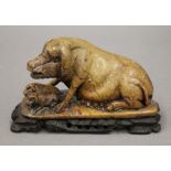 A Chinese soapstone carving of a sow and piglets, mounted on a wooden stand. 17 cm long overall.