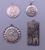 Four silver St Christopher medallions. The largest 3 cm high.