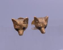 A pair of 9 ct gold ruby set fox mask ear studs, housed in a Garrard & Co box. Each 7 mm wide. 2.