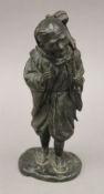 A Japanese Meiji period bronze model of a man with a monkey. 32 cm high.