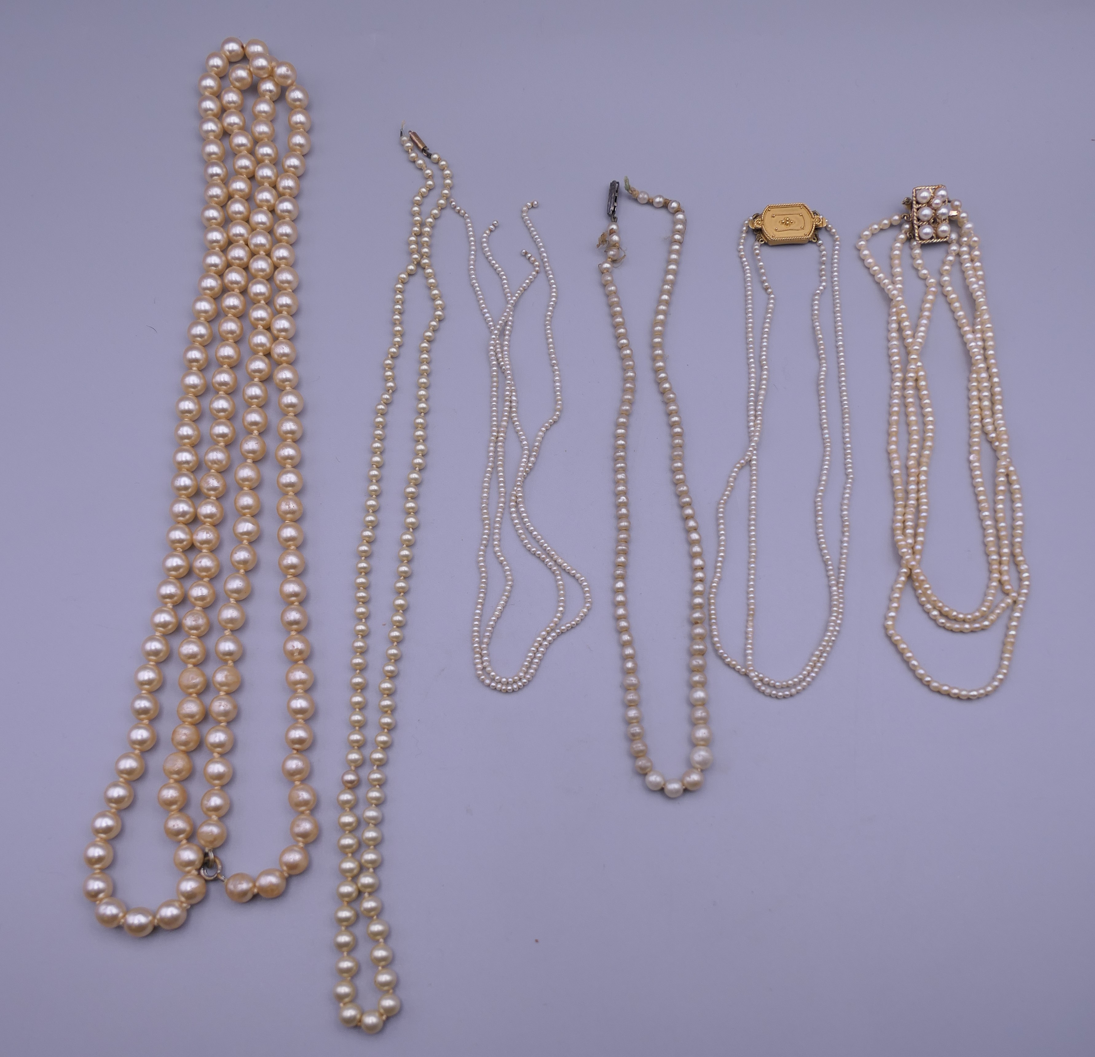A quantity of pearl necklaces, one with a 9 ct gold clasp.