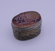 An Asian/Persian seal topped box. 3 cm wide.