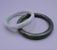 Two jade bangles. The largest 8.25 cm diameter.