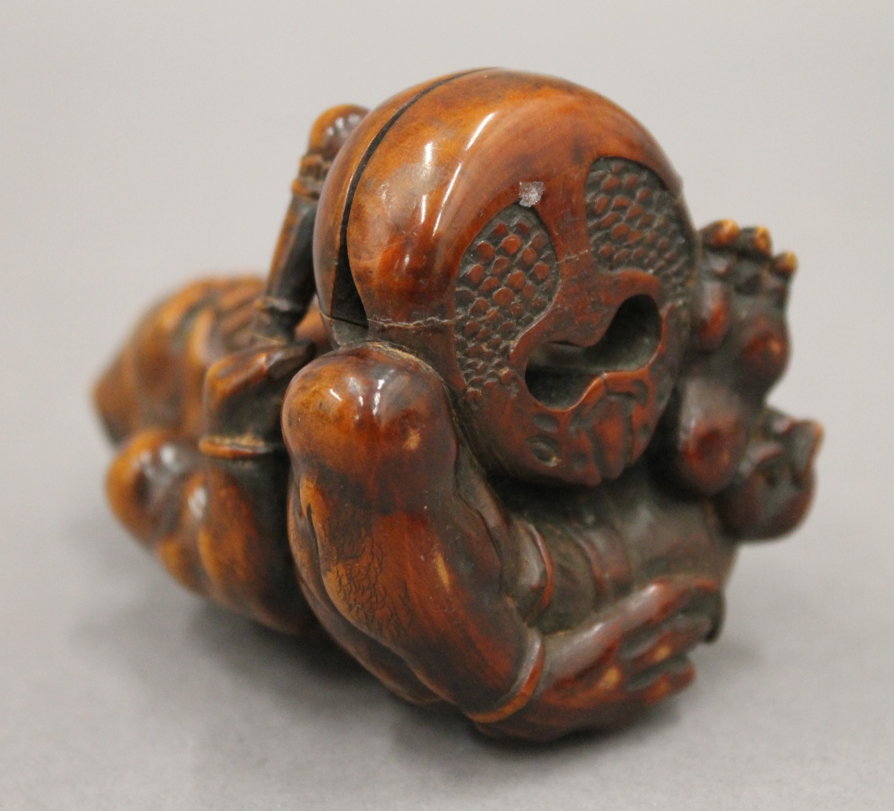 A boxwood okimono formed as a figure banging a drum. 7.5 cm high. - Image 5 of 5