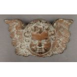 A Victorian cast iron cherub mask. 24 cm wide.