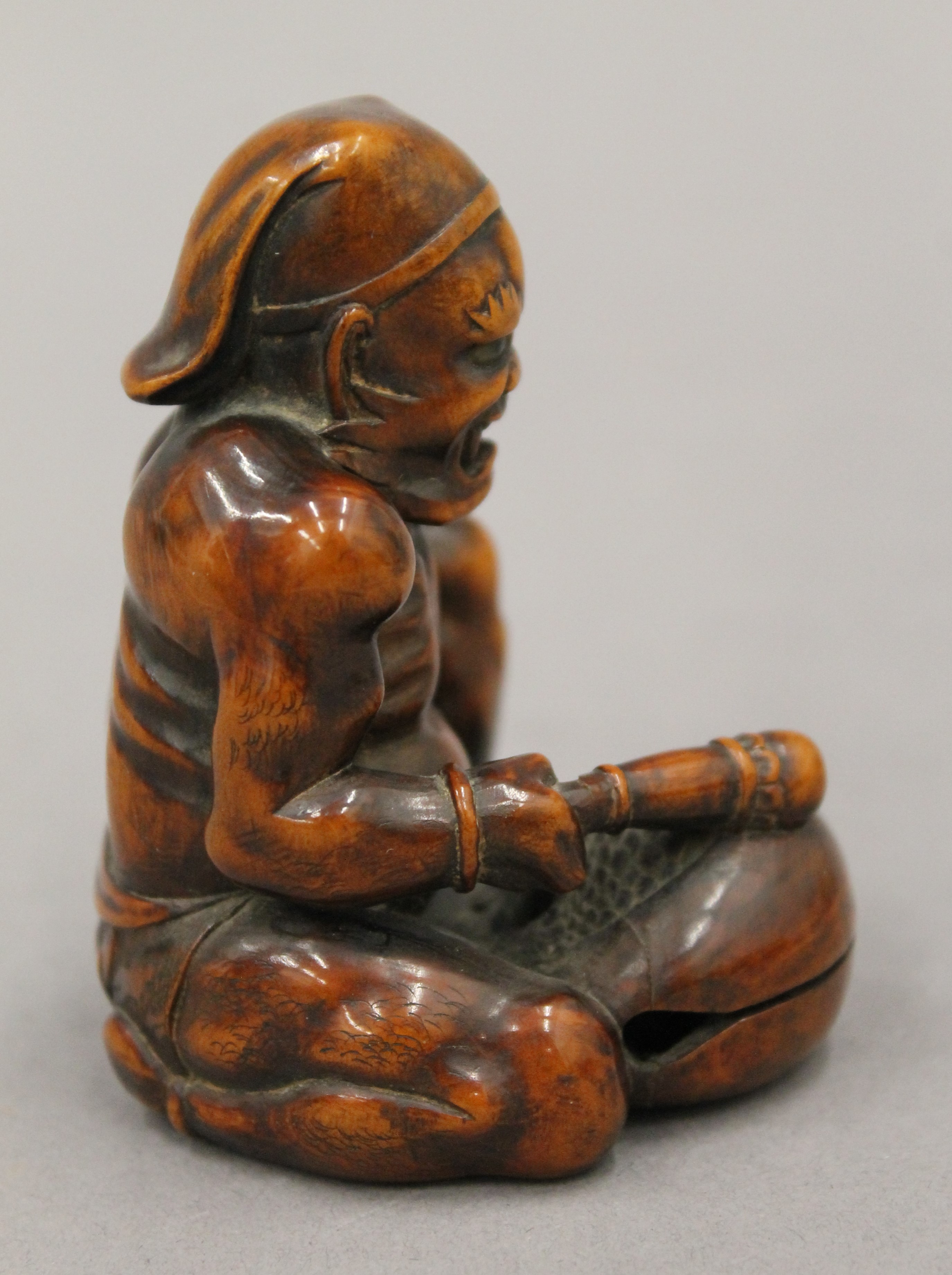 A boxwood okimono formed as a figure banging a drum. 7.5 cm high. - Bild 2 aus 5