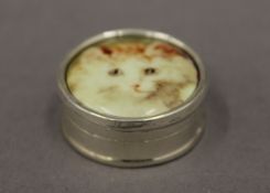 A round silver box decorated with a cat. 2.75 cm diameter.