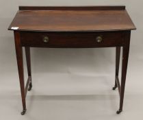 An Edwardian mahogany bow front single drawer side table. 91 cm wide.