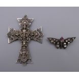 A Chester silver and paste butterfly brooch and a French unmarked white metal cross form pendant.