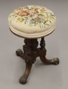 A Victorian tapestry covered walnut revolving piano stool.