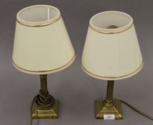 A pair of brass columnar lamps. Each approximately 39 cm high including shades.