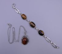 A vintage 835 silver bracelet set with three cabochon tigers eyes,