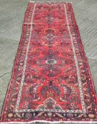 A red ground Hamadan runner. 388 x 86 cm.