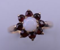 A 9 ct gold opal and garnet set cluster ring. Ring size N/O.