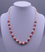 A pearl and coral necklace with a 14 ct gold clasp. 41 cm long.