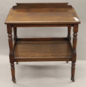 A Victorian walnut two-tier side table. 76 cm wide.