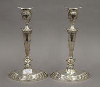 A pair of George III style silver candlesticks with oval bases, with removable sconces. 29 cm high.