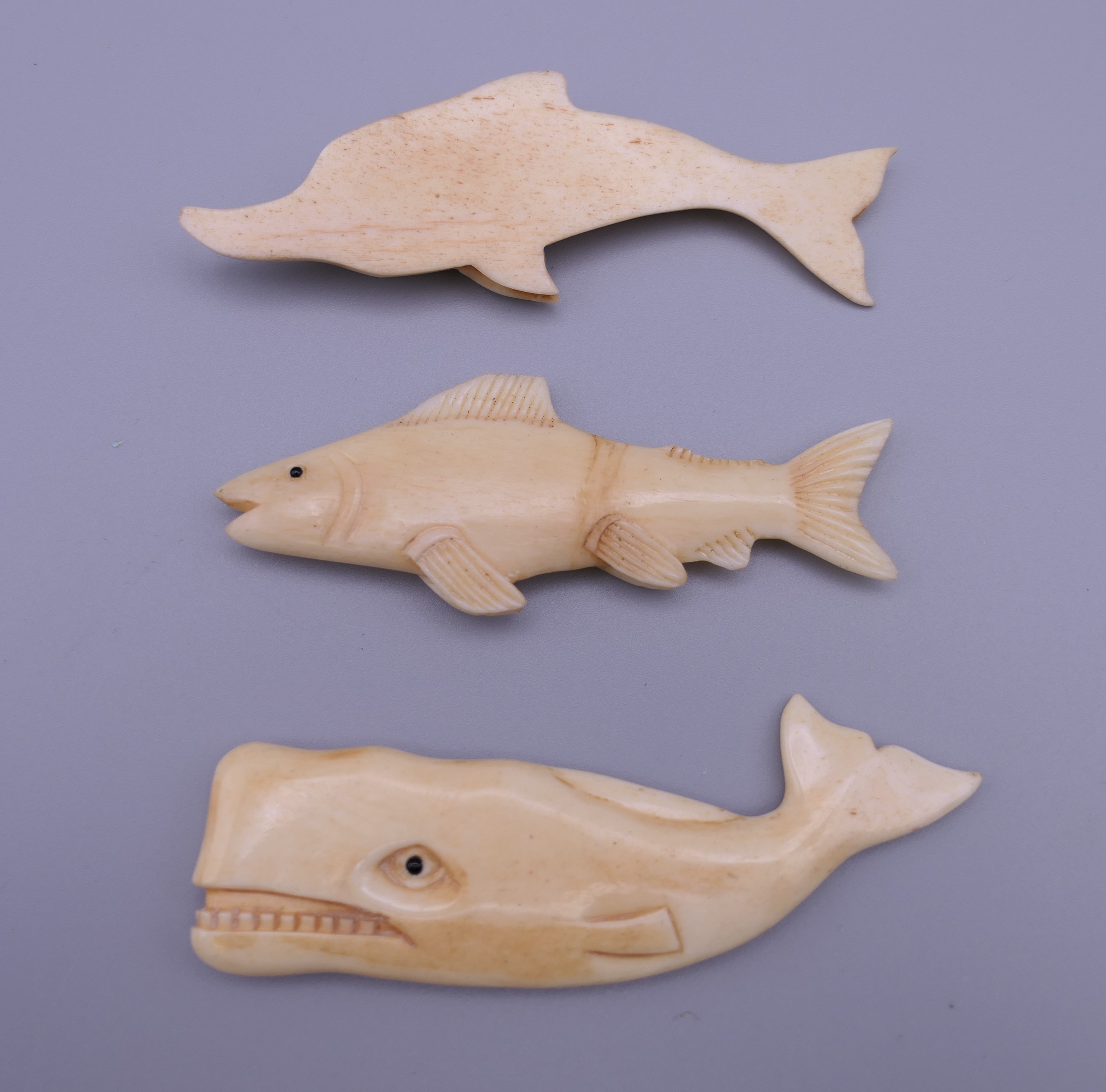 A carved bone fish, a carved bone sperm whale and a carved bone dolphin. The latter 8 cm long. - Image 2 of 3