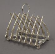 A silver plated rifle toast rack. 11.5 cm long.