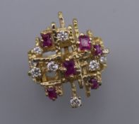 A Contemporary 18 ct gold ruby and diamond cluster ring. Ring size O. 14.2 grammes total weight.