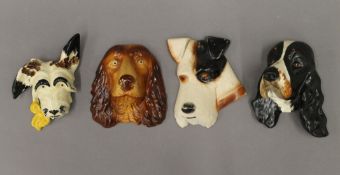 A Crown Devon dog wall mask and three others. The former 16.5 cm high.