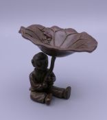 A bronze model of a boy holding a lily pad. 5.5 cm high.