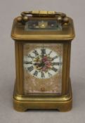 A miniature carriage clock with painted porcelain panels. 9.5 cm high overall.