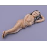 A carved bone figure of a nude lady. 9.5 cm long.