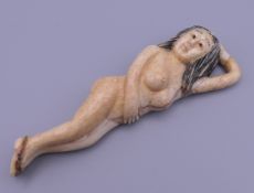 A carved bone figure of a nude lady. 9.5 cm long.