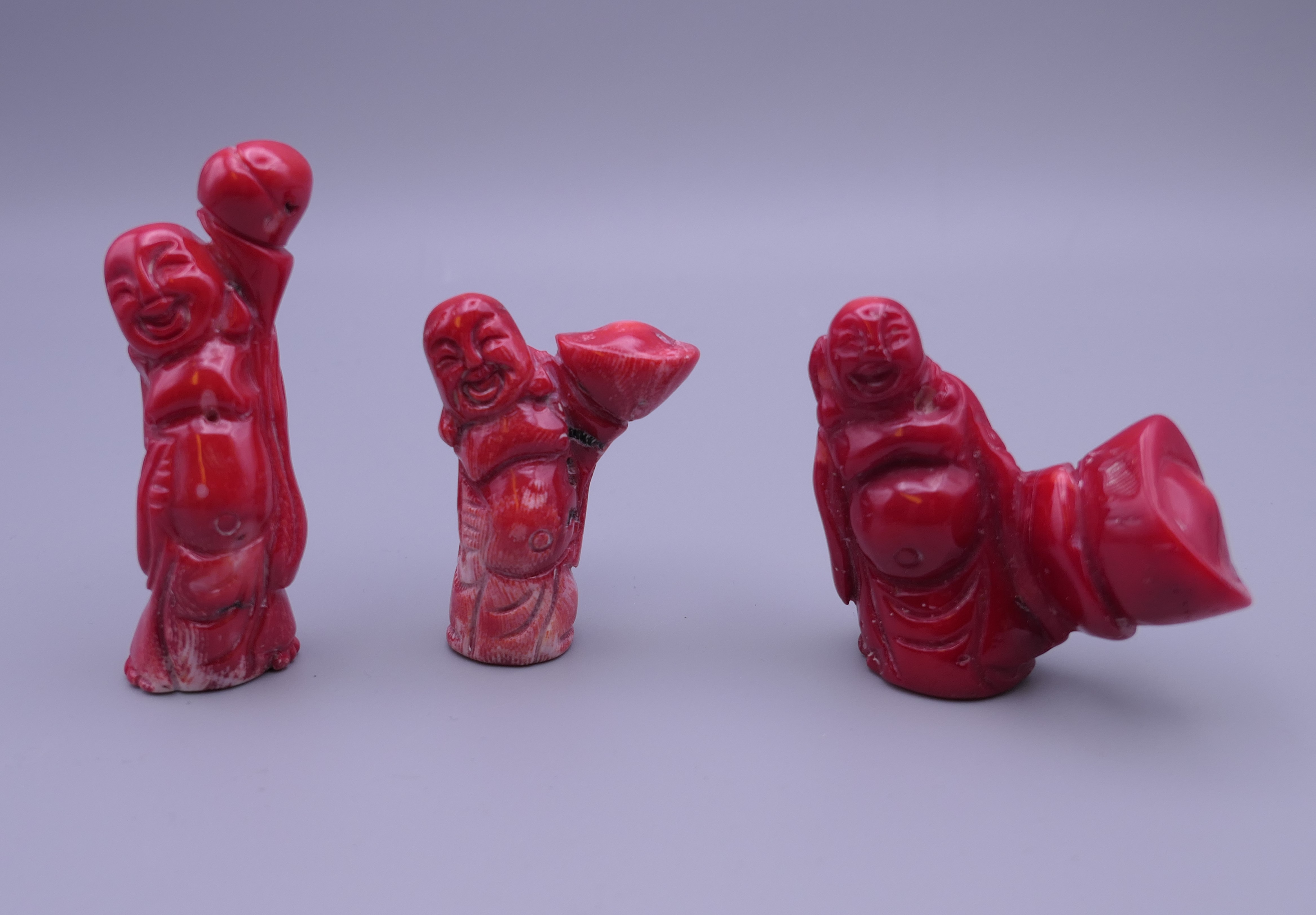 Three carved coral figures. The largest 7.5 cm high.