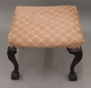 An upholstered mahogany stool. 55 cm wide.