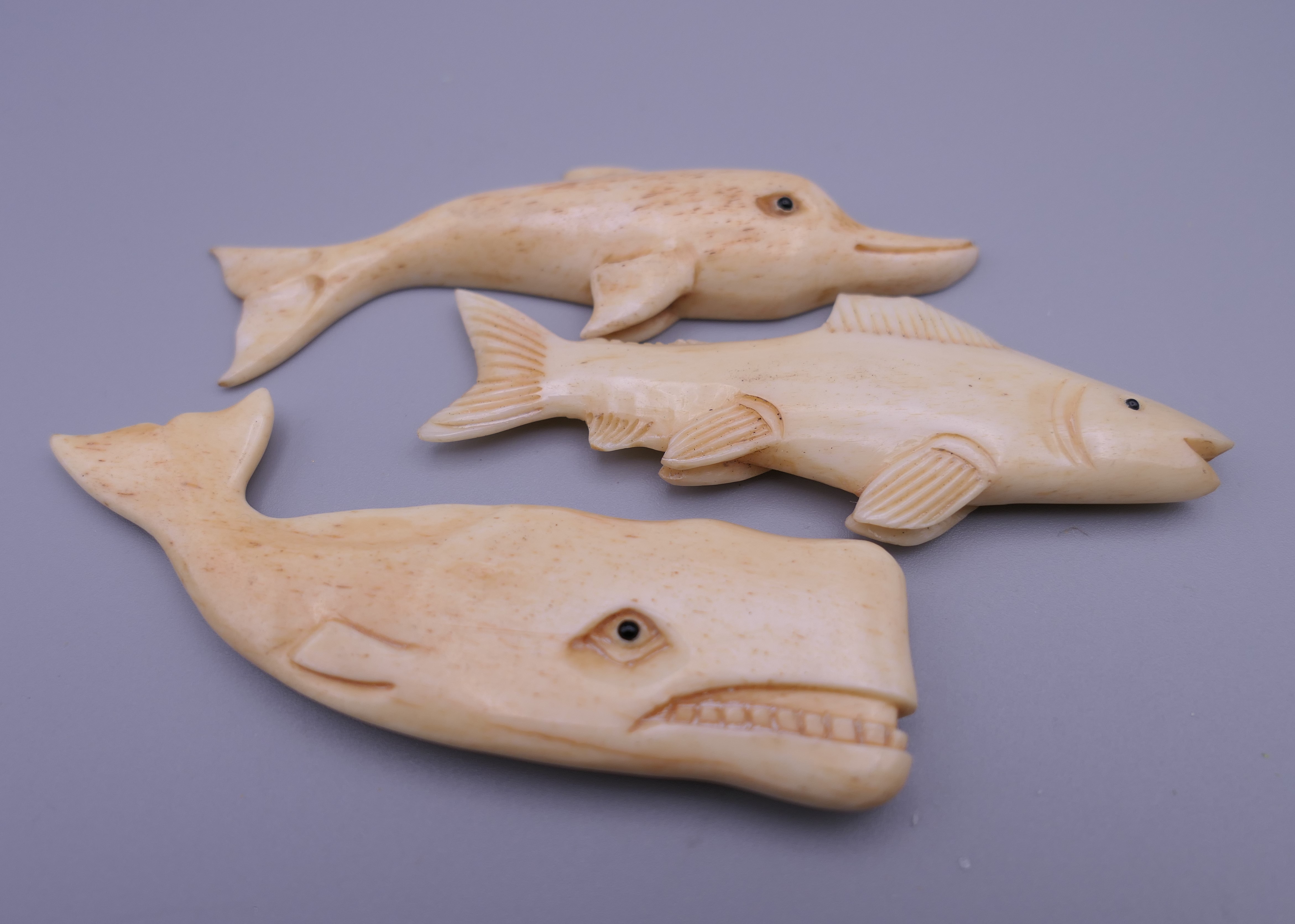 A carved bone fish, a carved bone sperm whale and a carved bone dolphin. The latter 8 cm long. - Image 3 of 3