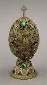 A silver gilt filigree egg enclosing an icon, bearing Russian marks. 15 cm high.