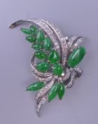 An 18 K white gold diamond and jade floral spray brooch. 5.5 cm wide. 15.1 grammes total weight.