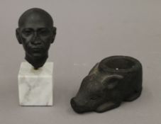 A small carved black basalt mortar in the form of a pig and a study of an Egyptian male head on a
