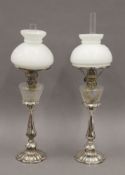 A pair of Victorian silver plated oil lamps, with cut glass reservoirs and opaline shades.