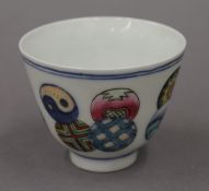 A porcelain tea bowl decorated with circular patterns. 6 cm high.