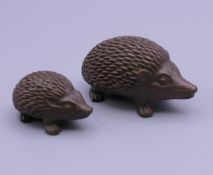 Two bronze hedgehogs. The largest 5 cm long.