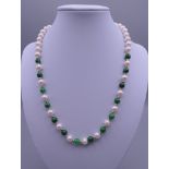 A pearl and jade necklace with a 14 ct gold clasp. 46 cm long.