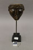 A replica BAFTA trophy, together with a BAFTA mask stickpin and brooch. The former 37 cm high.