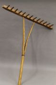 Four vintage farm tools, consisting of two hay forks and two rakes. The largest 174 cm long.