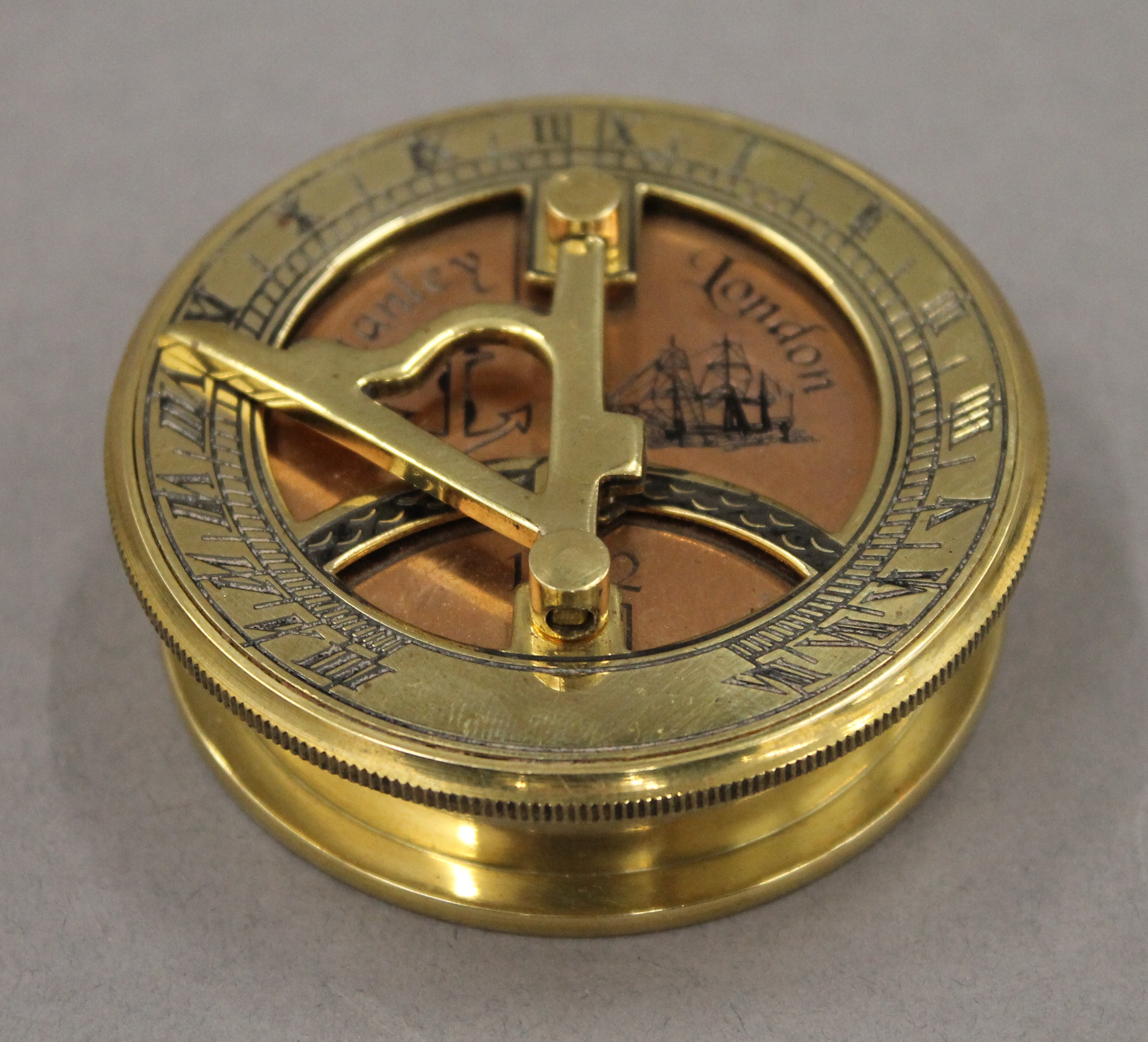 A brass and copper sundial compass. 6.5 cm diameter.