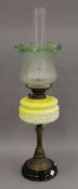 A Victorian oil lamp with yellow glass reservoir. 72 cm high overall.