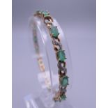 A 9 ct gold diamond and emerald bracelet. 18.5 cm long. 8.6 grammes total weight.