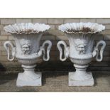A pair of twin handled cast iron garden urns.